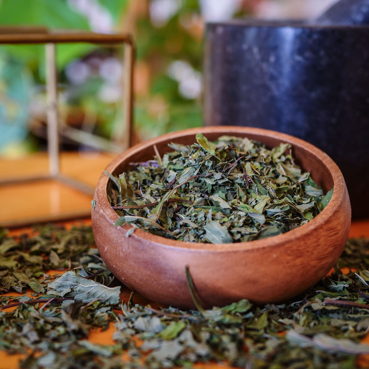 Un sachet de tisane de Menthe poivrée biologique La Val'Heureuse, mise en valeur dans un bol en bois.